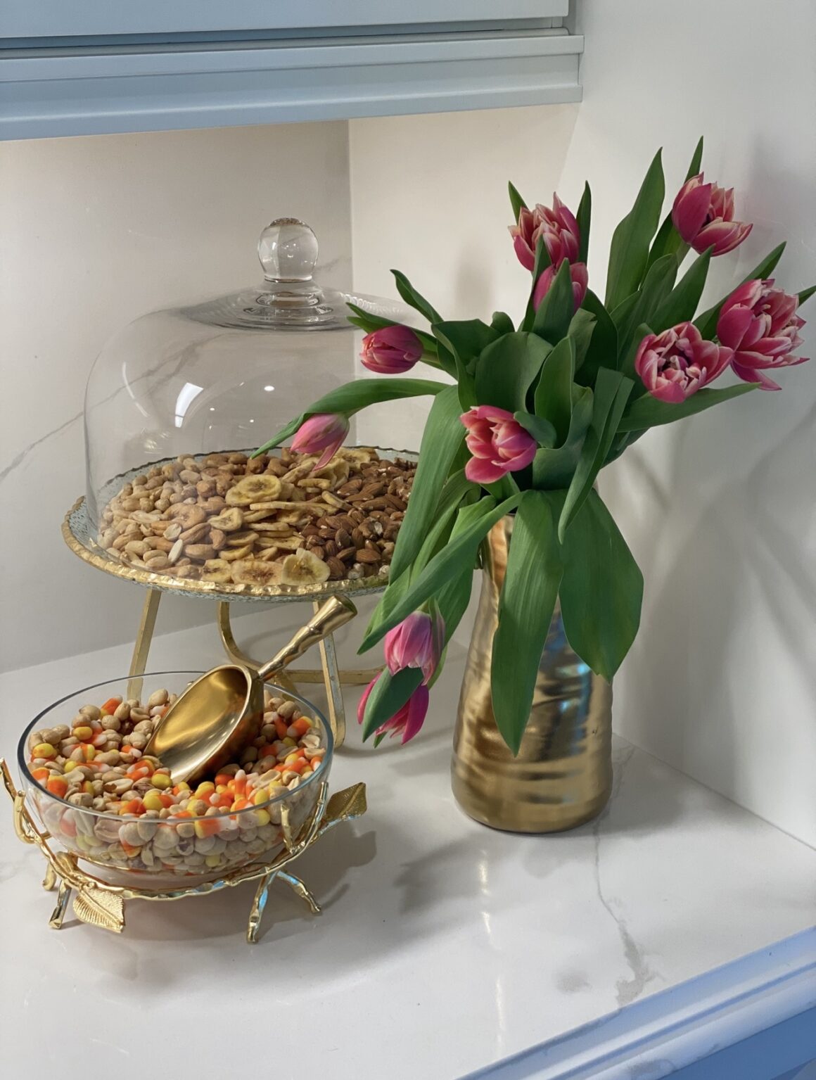 pink tulip flower arrangement in gold vase on kitchen counter