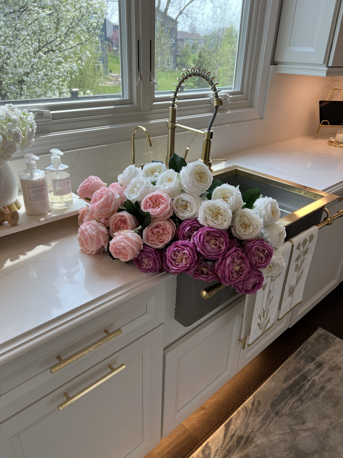 fresh pink and white roses arranged over farmhouse sink kitchen