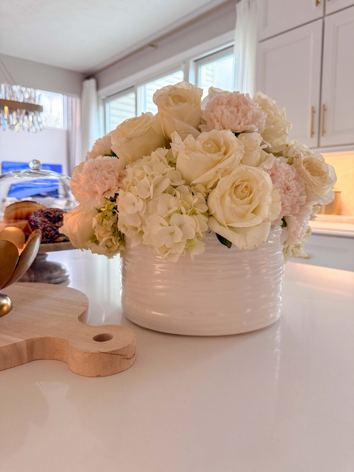 white hydrangea and rose arrangement on kitchen sink counter